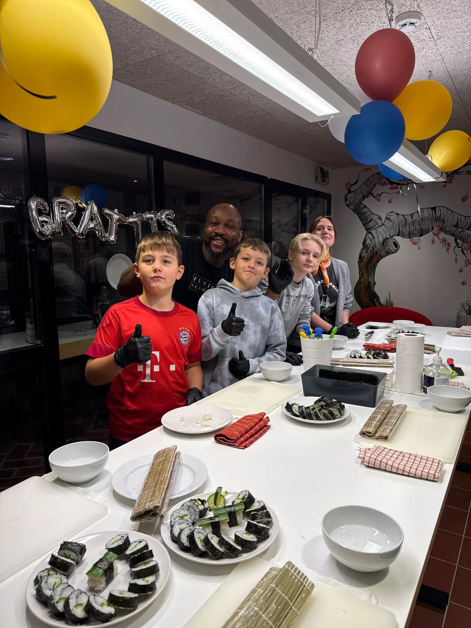 Sushi school with children showing off their sushi